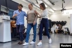 Marc Gauthier, 63, walks with the help of Eduardo Martin Moraud Head of Parkinson's Research at NeuroRestore and Camille Varescon, Clinical Research Engineer during a media presentation at the CHUV in Lausanne, Switzerland, November 2, 2023. (REUTERS/Denis Balibouse)