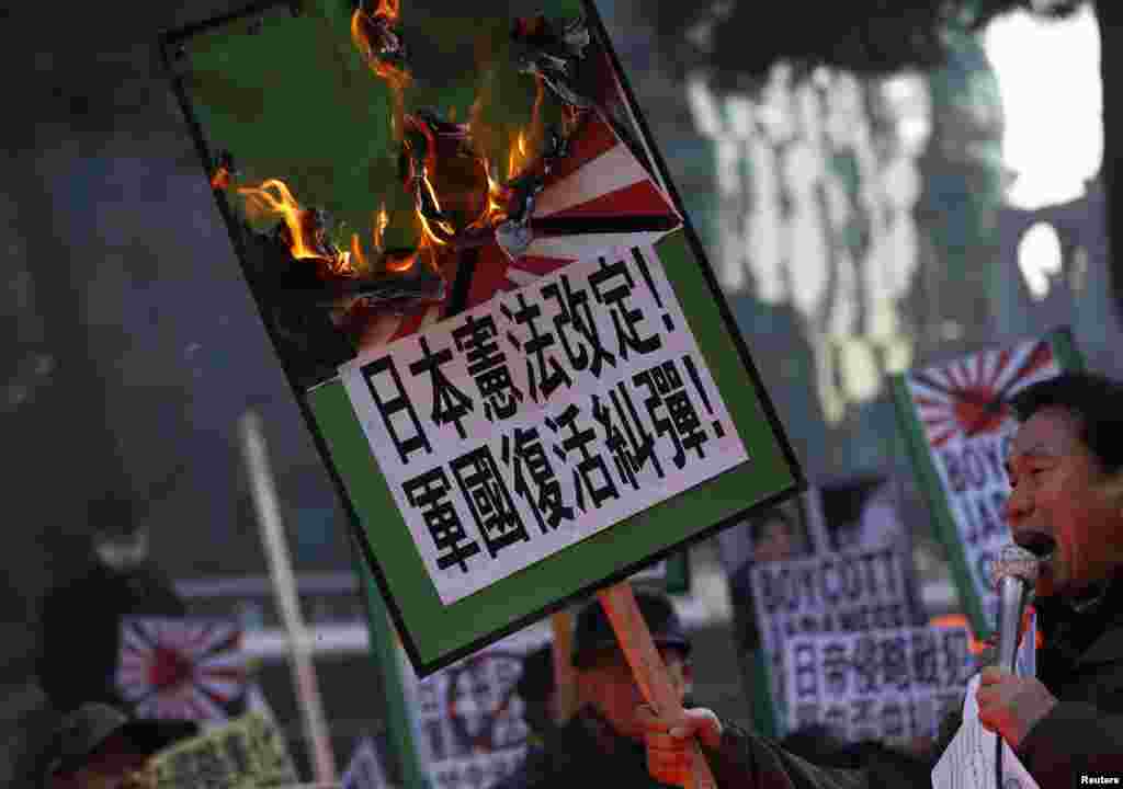 Pengunjuk rasa konservatif sayap kanan dan kelompok sipil anti-Jepang menyanyikan slogan-slogan yang mengecam kunjungan PM Jepang Shinzo Abe ke Kuil Yasukuni, di depan Kedutaan besar Jepang di Seoul.