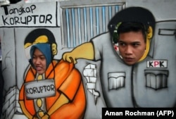 Para pendukung KPK berpawai dengan menggunakan kardus bergambar petugas KPK menangkap koruptor di Malang, Jawa Timur, 23 Januari 2015. (Foto: AFP/Aman Rochman)