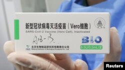 一名护士手持中国国药集团生产的新冠疫苗。（2021年4月15日）