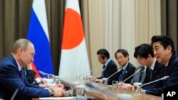 资料照片：2014年2月8日，俄罗斯总统普京（左）和日本首相安倍（右）在俄罗斯索契会晤。