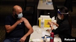 Nurse immuniser Kelie Lee prepares to administer the AstraZeneca vaccine 