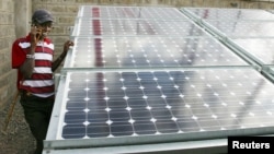 Un garde Maaai se tient près d'un panneau solaire à la station de transmission de Kajiado, au sud de Nairobi, Kenya, le 1 octobre 2009.