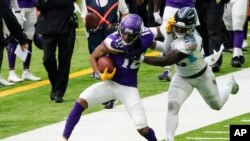 FILE - Minnesota Vikings wide receiver Justin Jefferson, left, tries to break a tackle by Tennessee Titans inside linebacker Jayon Brown during the first half of an NFL football game in Minneapolis, Sept. 27, 2020.