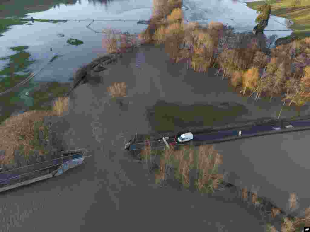 Jembatan Llanerch di atas sungai Clwyd tampak tergenang banjir, dekat kota Saint Asaph di Wales utara, setelah sebagian besar wilayah Inggris tengah dan utara serta Wales terperangkap di jalur Badai Christoph, Kamis 21 Januari 2021. (Foto: Jon Super / AP)