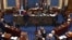 FILE - In this image from video, lawmakers and staff members confer on the floor of the Senate at the U.S. Capitol in Washington, Feb. 13, 2021.