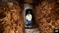 Anak-anak Suriah keluar dari terowongan bawah tanah yang dibuat oleh ayah mereka untuk berlindung dari serangan udara dan darat yang dilancarkan oleh pemerintah Suriah di desa Jirjanaz, propinsi Idlib, Suriah (Foto: dok). 