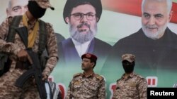 چند ستیزه‌جوی حوثی مقابل تصویری از قاسم سلیمانی، حسن نصرالله، و اسماعیل هنیه