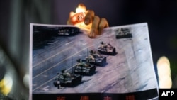 在香港维多利亚公园参加纪念六四事件31周年的一名男子手持天安门广场“坦克人”的照片。（2020年6月4日）