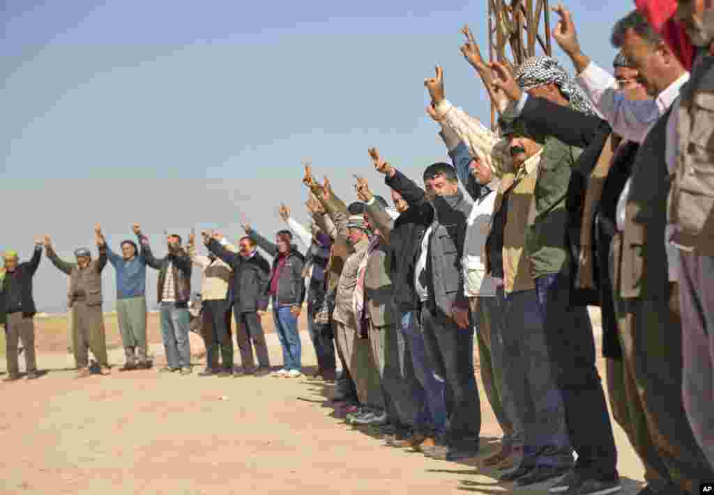 Des Kurdes font le signe de victoire lors d&#39;un rassemblement de solidarité avec la ville syrienne de Kobané dans le village de Caykara, Turquie, le 11 novembre 2014.