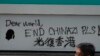 A man walks past a wall with the words "Liberate Hong Kong- Dear World End Chinazi Please" in Hong Kong, Oct. 7, 2019.