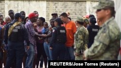 2019年5月23日墨西哥: 移民与警察交谈。在一边观察的是国民警卫队员