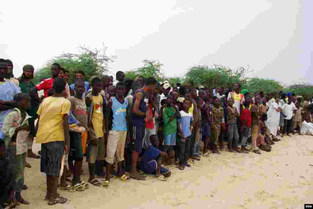 Local residents, including many children, look on as Islamist group Ansar Dine prepares to amputate the hand of a young man found guilty of stealing rice, in Timbuktu, Mali.