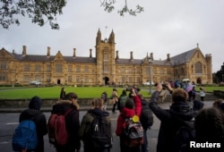 资料照：参观者在澳大利亚悉尼大学主楼前拍照。（2016年8月5日）