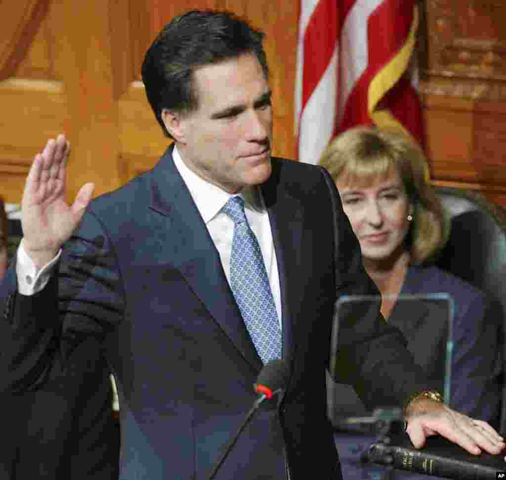 Mitt Romney, accompanied by Lt. Gov.-elect Kerry Healy, takes the oath of office as governor of Massachusetts at the Statehouse in Boston, January 2, 2003.