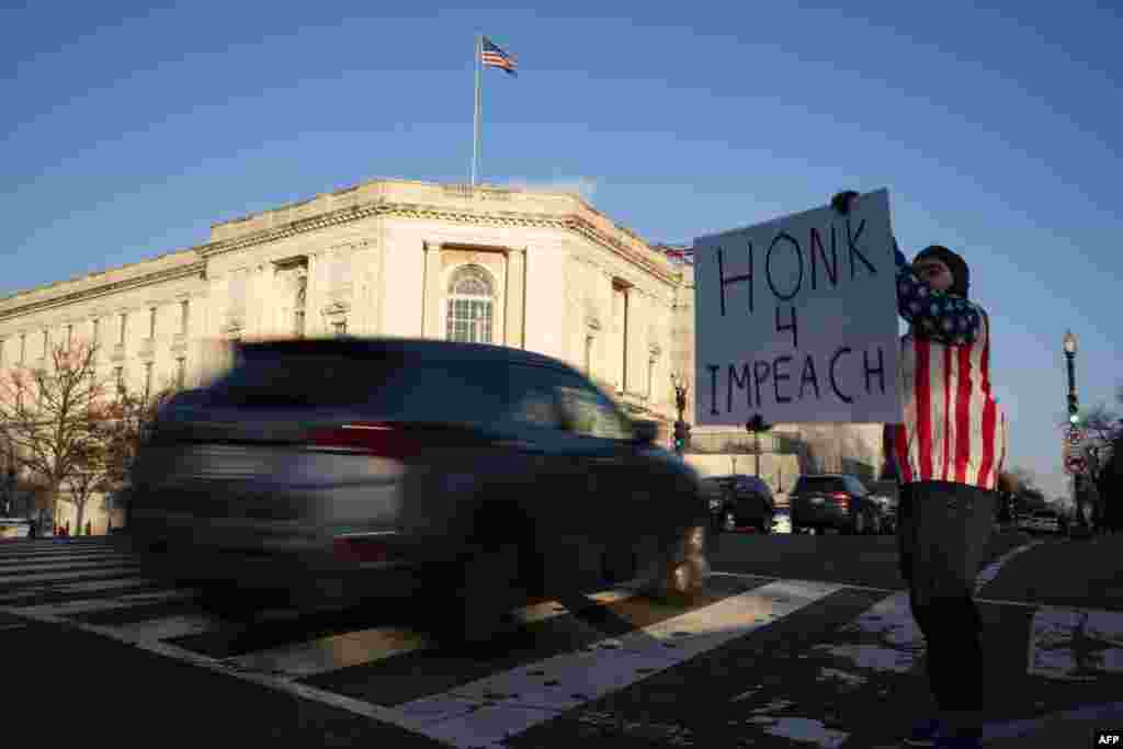 Mtu akiandamana nje ya&nbsp; bunge la Marekani Washington, DC Disemba 18, 2019 wakati baraza la Wawakilishi likijadili vifungu viwili vya kumfungulia mashtaka Rais Donald Trump. (Photo by Alex Edelman / AFP)