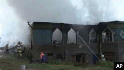 Para petugas berupaya memadamkan api di rumah sakit jiwa di desa Luka, wilayah Novgorod, Rusia, Jumat pagi (13/9).