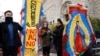 Maro Park, left, of Fairfax, Virginia, holds a sign saying "Congress Must Act Now," next to Paola Marquez and LaRia Land, both of Silver Spring, Maryland, as they stand by a banner of the Lady of Guadalupe, during a march with others in support of the Deferred Action for Childhood Arrivals (DACA) program, on Capitol Hill, Dec. 12, 2017, in Washington. 