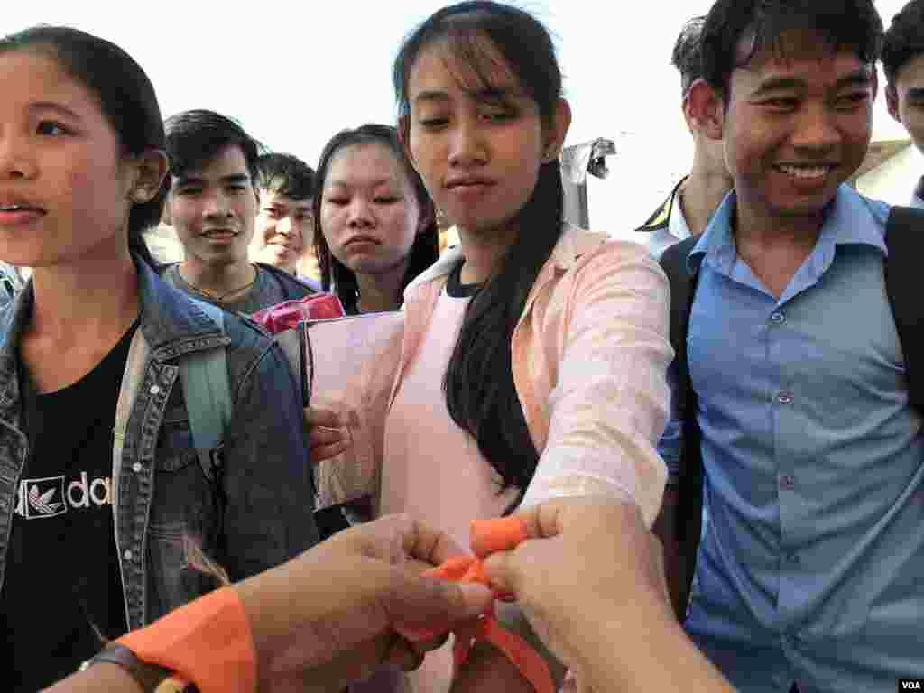 យុវជន​ឲ្យ​គេ​ចង​ខ្សែបូរ​ពណ៌​ទឹក​ក្រូច​តំណាង​ឲ្យ​ការ​បញ្ចប់​អំពើ​ហិង្សា​លើ​កុមារី និង​ស្រ្តី ក្នុង​ពេល​ប្រាព្ធ​ទិវា​សិទ្ធិ​មនុស្ស​អន្តរជាតិ ១០ ធ្នូ ​លើកទី​៧១ នៅ​ពហុ​កីឡា​ដ្ឋាន​ជាតិ​អូឡាំពិក នៅ​ថ្ងៃទី​០៧ ខែ​ធ្នូ ឆ្នាំ​២០១៩។​ (កាន់ វិច្ឆិកា/VOA)