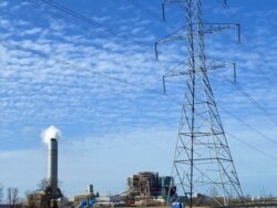 A high-voltage power transmission line is seen in front of the La Cygne Generating Station, a coal-fired power plant in Kansas, in March 2021. (Steve Herman/VOA)