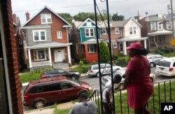 FILE - Maria Williams stands on her front porch in Wilmington, Delaware, the day after her teenage son and daughter were shot and wounded while standing on the same porch, July 27, 2017.