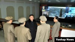 12일 장거리 로켓 `은하 3호' 발사 직전 위성관제종합지휘소를 찾은 김정은 북한 국방위원회 제1위원장(가운데).
