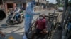 A health worker takes a nasal swab sample of a cartpuller during random testing for COVID-19 in a market in Gauhati, India.