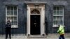 FILE - A street cleaner clears fall leaves from the front of 10 Downing Street, London, Britain, Nov. 6, 2019. 