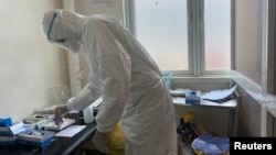 FILE - A medical staff member wearing protective gear prepares to take care of patients, at a hospital in Douala, Cameroon, April 27, 2020. The conflict in the country's western regions has made it difficult for terminally ill Cameroonians there to receive palliative care.