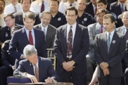 FILE - President Bill Clinton signs the $30 billion crime bill during a ceremony on the South Lawn of the White House in Washington.