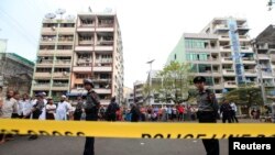 Police stand near a mosque and school dormitory that were damaged by a fire in Rangoon, Burma, April 2, 2013.