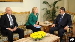 La secrétaire d'Etat Hillary Clinton (au milieu) rencontrant le président égyptien Mohammed Morsi (à droite) et le ministre égyptien des Affaires étrangères, Mohammed Kamel Amr, au Caire le 21 novembre 2012