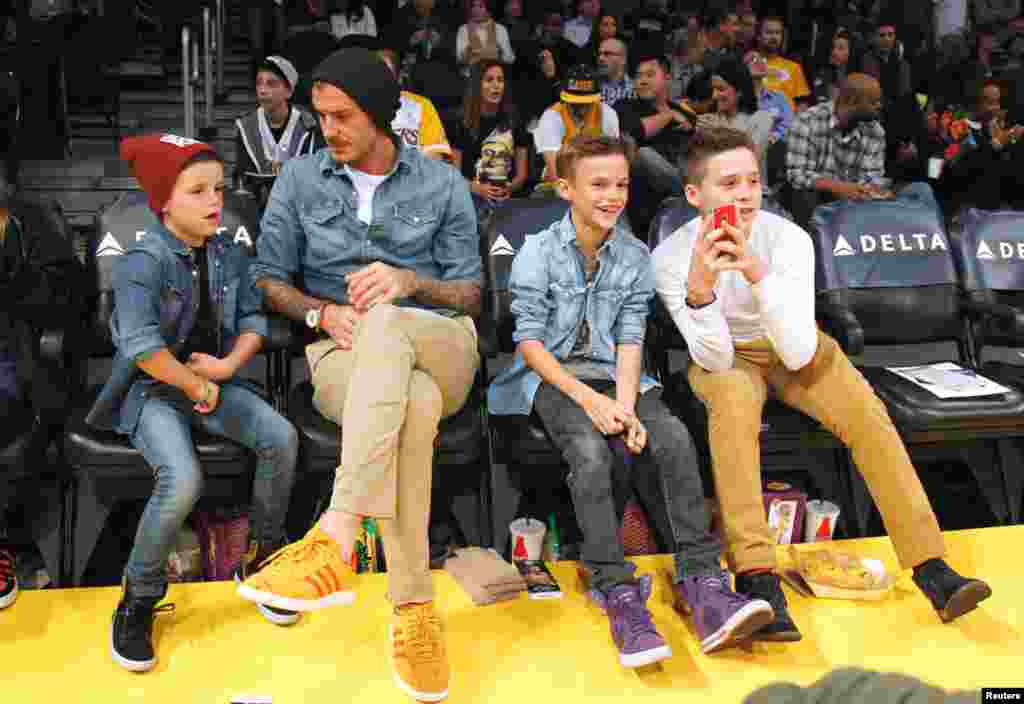 Beckham sits courtside with his sons Cruz (L), Romeo (2nd R) and Brooklyn (R) before the NBA basketball game between the Los Angeles Lakers and Phoenix Suns in Los Angeles, November 16, 2012.