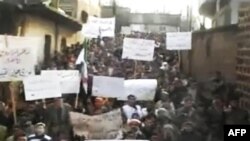 əvəskar tərəfindən çəkilən videodan alınan şəkil Shaam News Network tərəfindən yayılıb və Yanvarın üçündə Hamada çəkilib. Şəkli yayan Associated Press onun yeri vaxdı və dürüstlüyünə zəmaət verə bilmir.