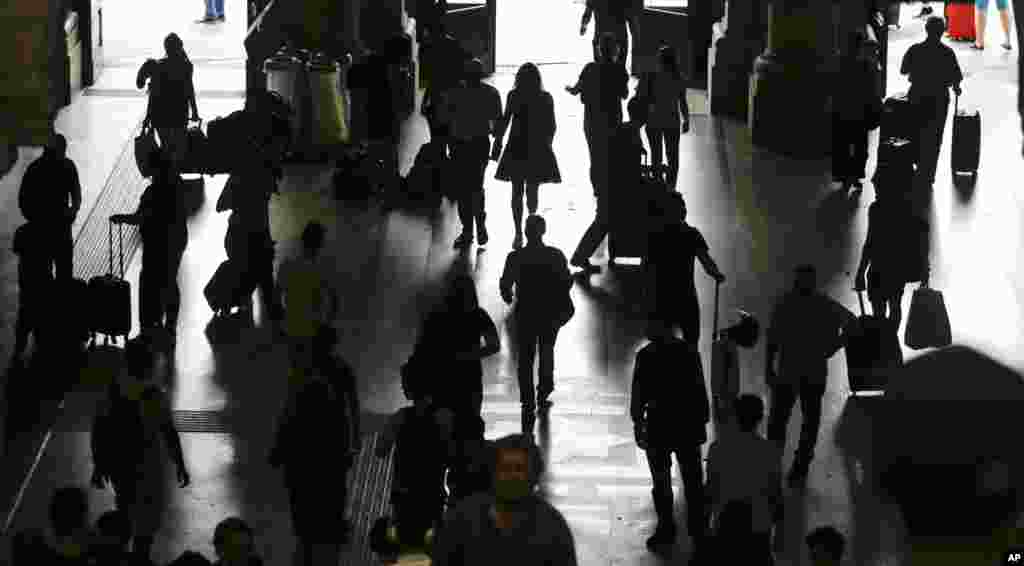 People are silhouetted as they walk in a railway station, in Milan, Italy, during a general transportation strike. Travelers faced train and flight cancellations, commuters crowded the streets in private cars, due to the strike against privatization of the transportation sector.&nbsp;