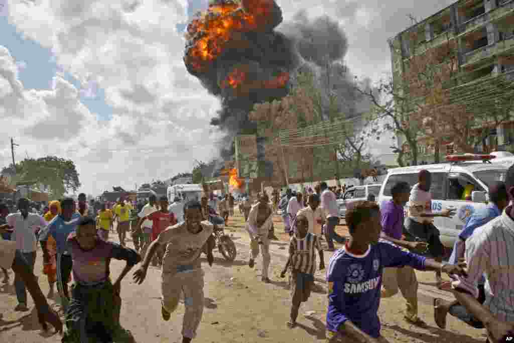 Somalis run from a fireball and explosion during a market fire in the capital Mogadishu.