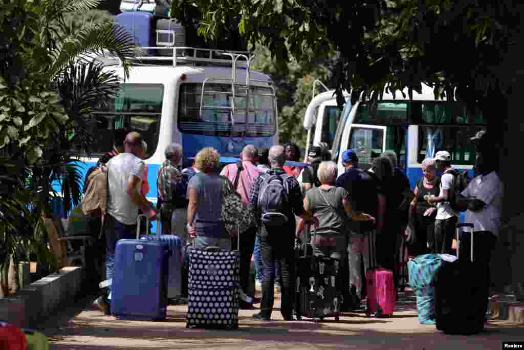 Des touristes se sont réunis pour monter dans des bus et aller à l'aéroport, à Banjul, en Gambie, le 18 janvier 2017.