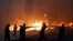 Firefighters, soldiers and local residents carry a hose as a wildfire burns in the town of Rafina, near Athens, Greece, July 23, 2018. 