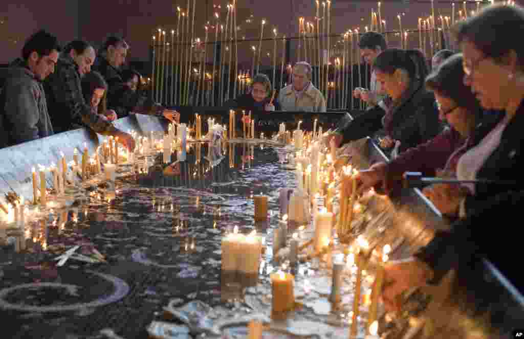 Jemaat menyalakan lilin di Basilika Perawan Aparecida, santa pelindung Brazil, di kota Aparecida, Brazil (23/7).&nbsp;&nbsp;(AP/Andre Penner)