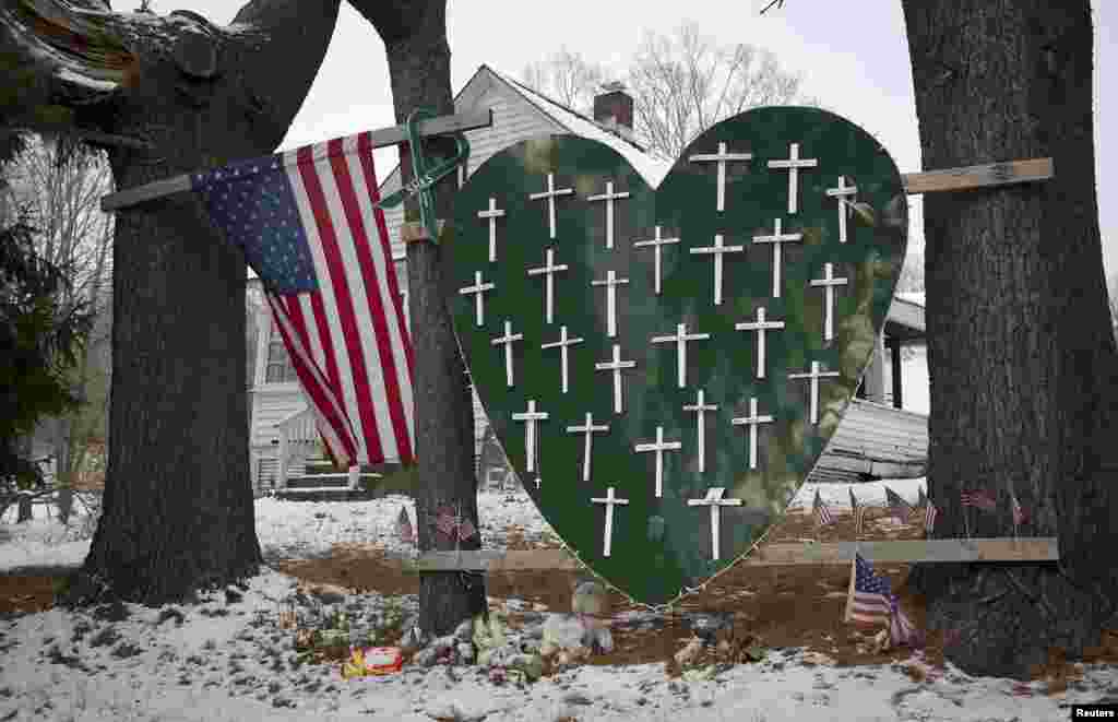 Papan berbentuk hati dihiasi tanda-tanda salib untuk memperingati 26 korban penembakan di SD Sandy Hook&nbsp; di Newtown, Connecticut. Tanggal 14&nbsp; Desember menandai peringatan satu tahun dari peristiwa penembakan yang dilakukan oleh seorang pelaku yang bunuh diri setelah menembak para korbannya. 