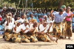 A woman dancing during the food distribution launch. (L. Masina/VOA)