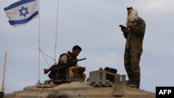 一名以色列士兵站在一辆位于以色列与黎巴嫩边界地区的坦克上祈祷。（2023年10月30日）