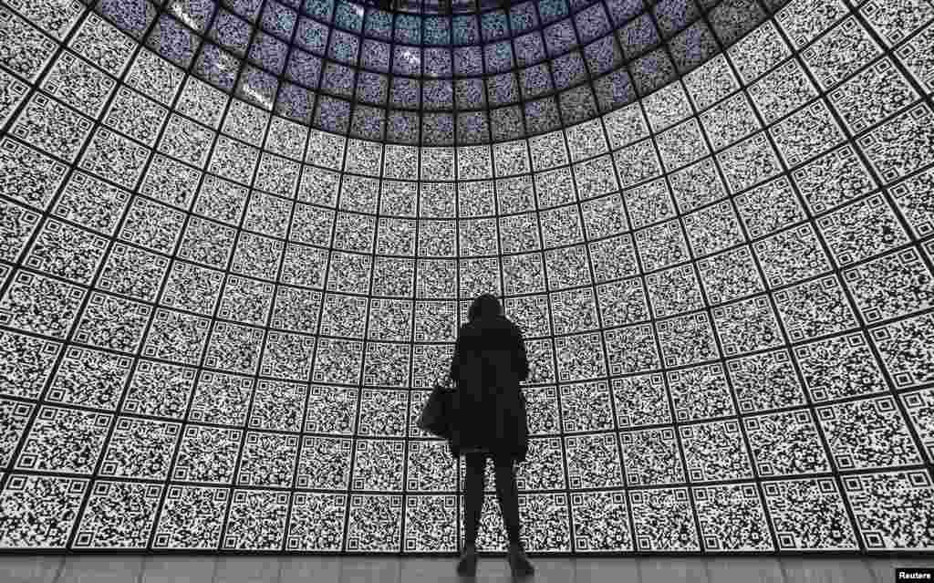 A visitor stands in front of QR-codes information panels during a ceremony to open an information showroom dedicated to the Zaryadye park project in central Moscow, Russia. The showroom, shaped as a dome which houses exhibition halls covered with QR-codes information panels and displaying digital illustration of the project, was opened by Moscow&#39;s Mayor Sergei Sobyanin on the site of the future park in a few minutes walk distance from Red Square and the Kremlin, according to organizers.