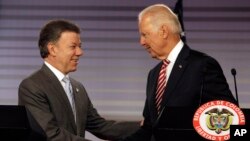 U.S. Vice President Joe Biden, right, shakes hands with Colombia's President Juan Manuel Santos after giving a joint news conference at the presidential palace in Bogota, Colombia, June 18, 2014