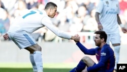 Christiano Ronaldo aidant Leonel Messi à se relever lors du classico de la Liga entre le Real Madrid et Le FC Barcelone à Santiago Bernabeu, Madrid, 23 Décembre 2017 (AP Photo/Francisco Seco)