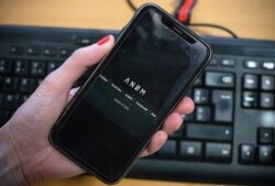 The ANOM logo is displayed on the screen of a smartphone in Paris, June 8, 2021.