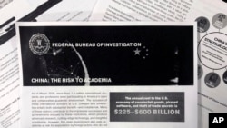 A photo shows a copy of an FBI pamphlet and related emails, Oct. 4, 2019. The FBI’s outreach to American colleges about the threat of economic espionage includes this pamphlet that warns specifically about efforts by China to steal academic research.