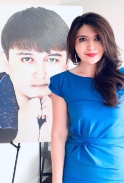 阿萨特站在她弟弟伊克帕的照片前