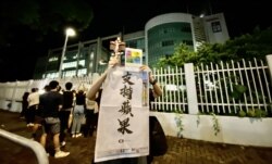 有市民高举苹果日报26周年报庆的头版广告，支持该报编采人员。 (美国之音/汤惠芸)