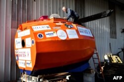 FILE - Jean-Jacques Savin works on the construction of a ship made from a barrel at the shipyard in Ares, southwestern France, Nov. 15, 2018.